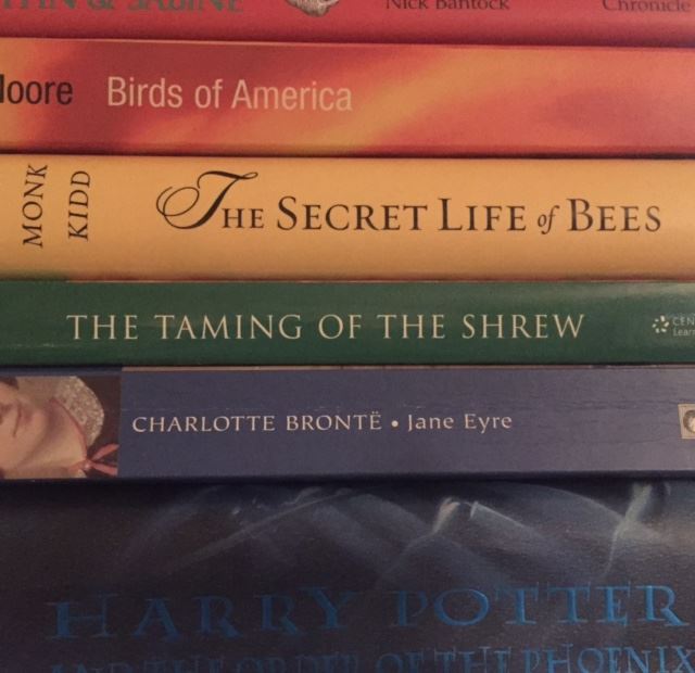 Photo of a rainbow colored stack of books.