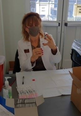 Pharmacist Diane Briner of West Concord Pharmacy prepares a COVID vaccine dose at one of the vaccina